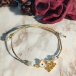 Βραχιόλι Γούρι 2026 επίχρυσο Ρόδι με Μάτι και λευκό Σμάλτο σε χρυσό Γυαλιστερό κορδόνι